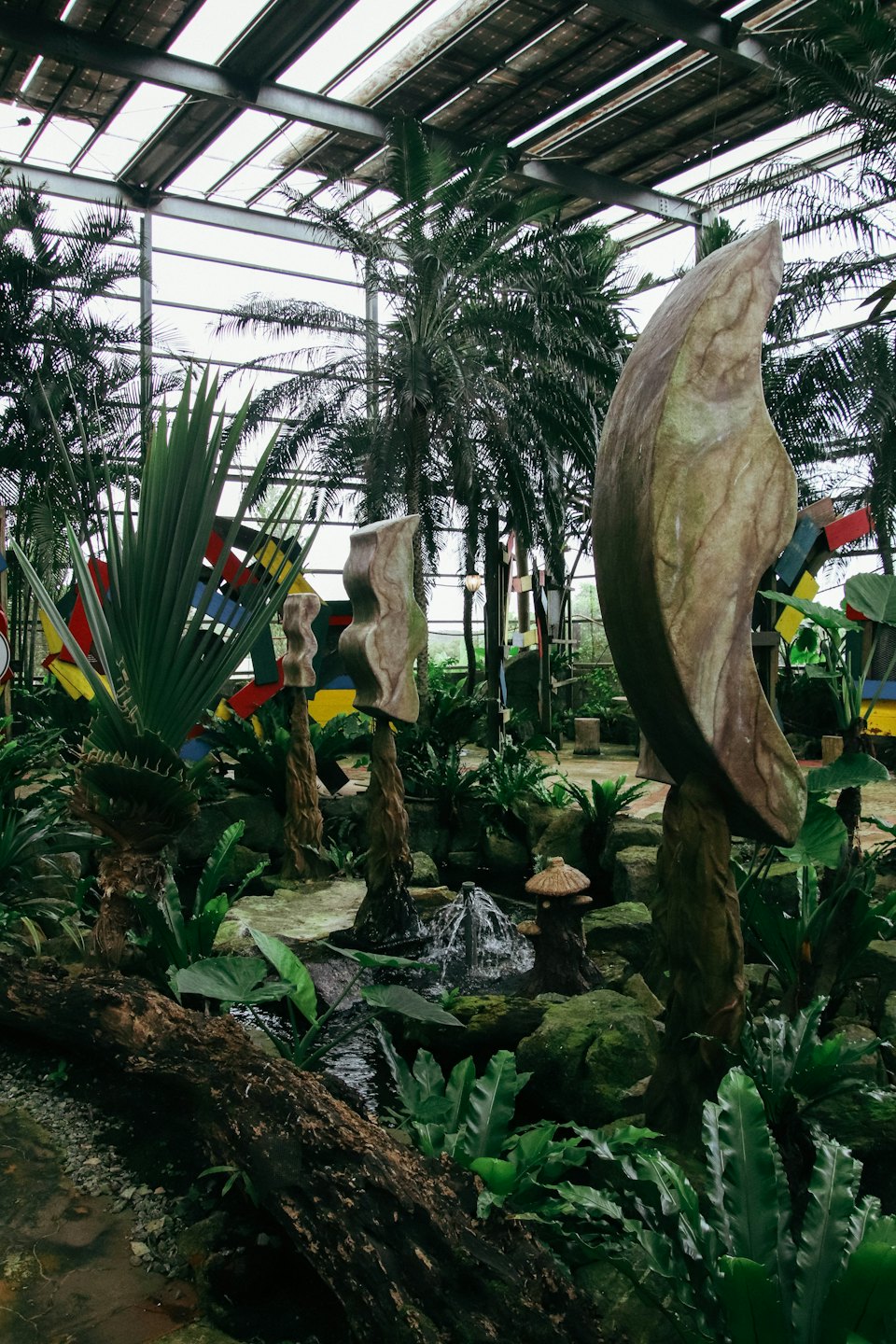 Bogate atrium wewnątrz z drzewami palmowymi, kamiennymi rzeźbami i fontannami.